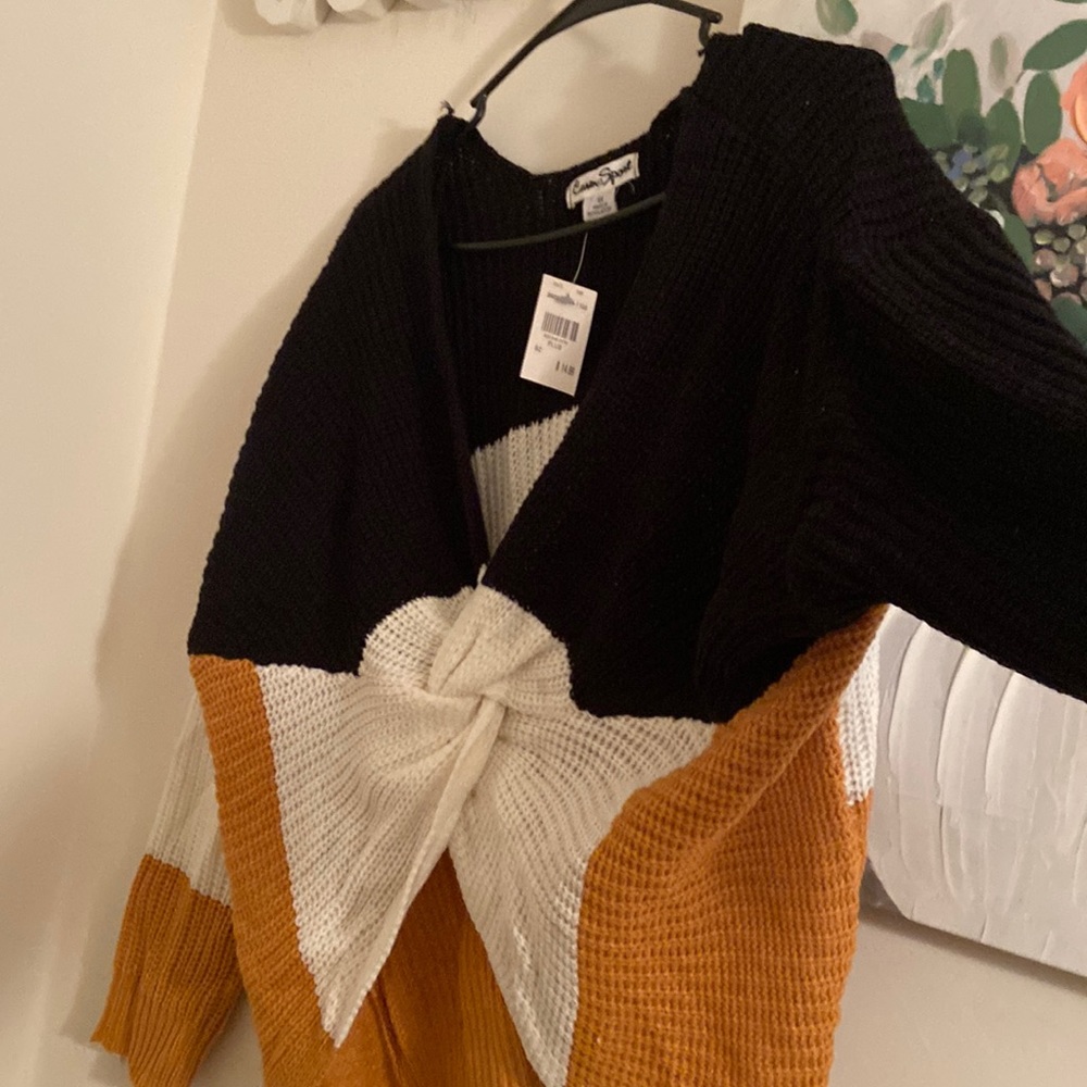 Black and gold sweater with a twist in the front.